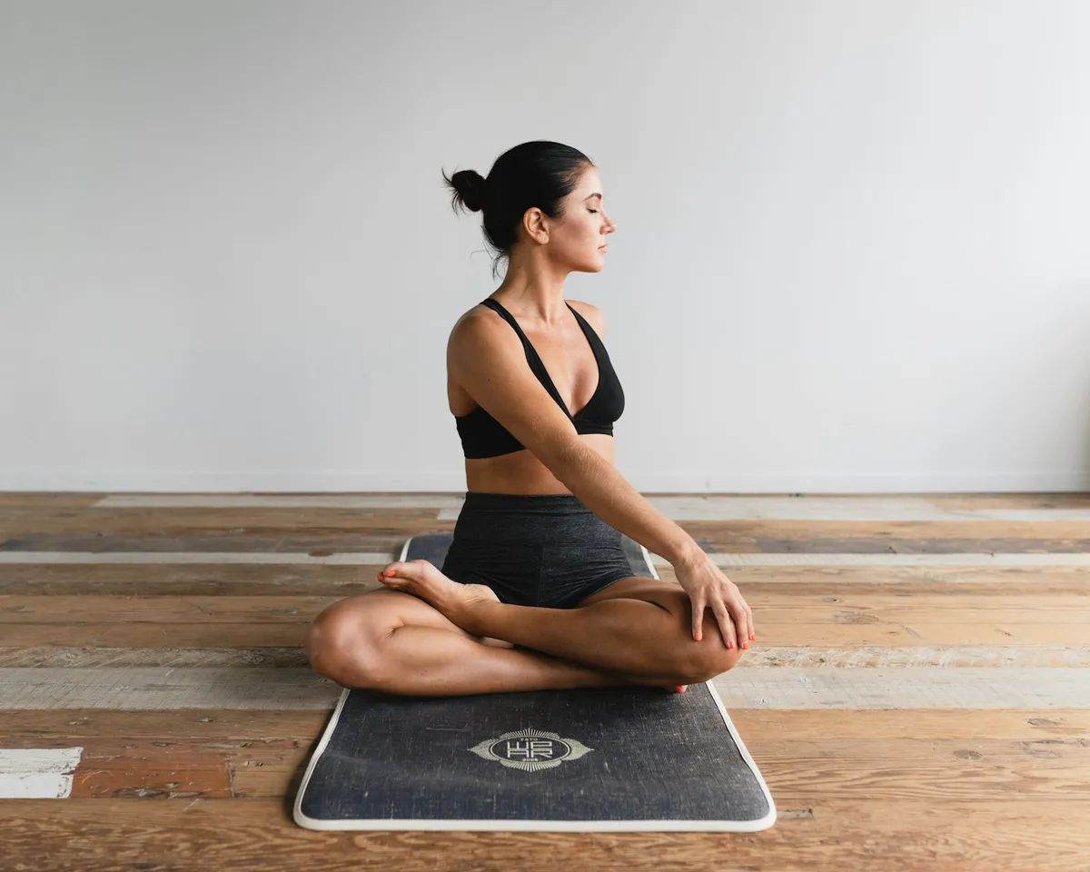 Yoga student in a seated twist half lotus pose